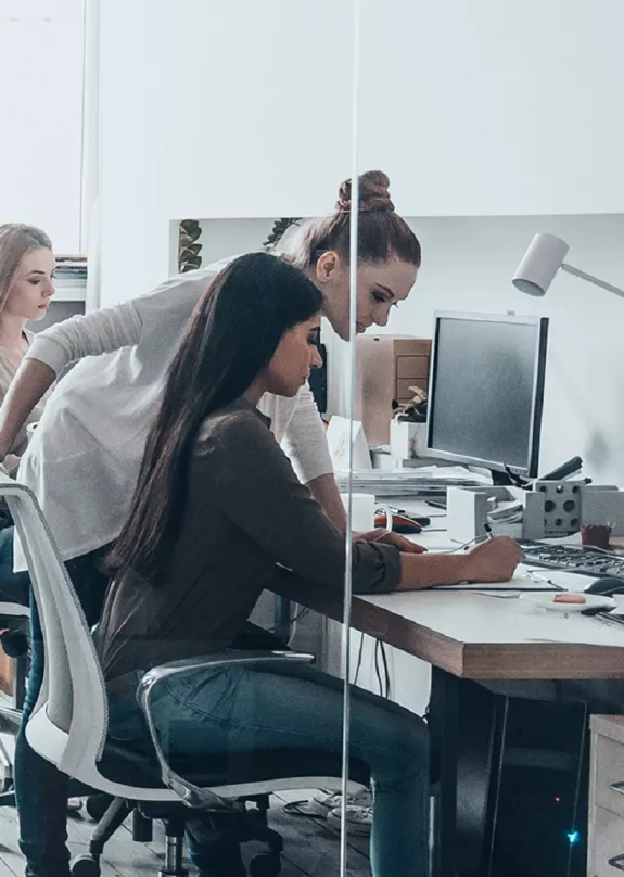 People working at desks and stood around desks
