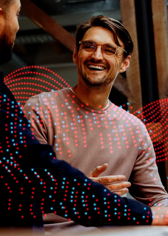 Two men having a conversation by a laptop