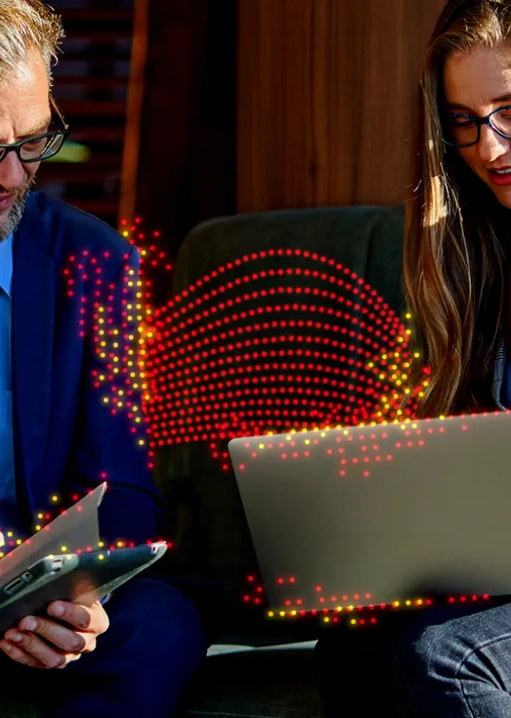 Man and a Woman talking whilst looking at a laptop